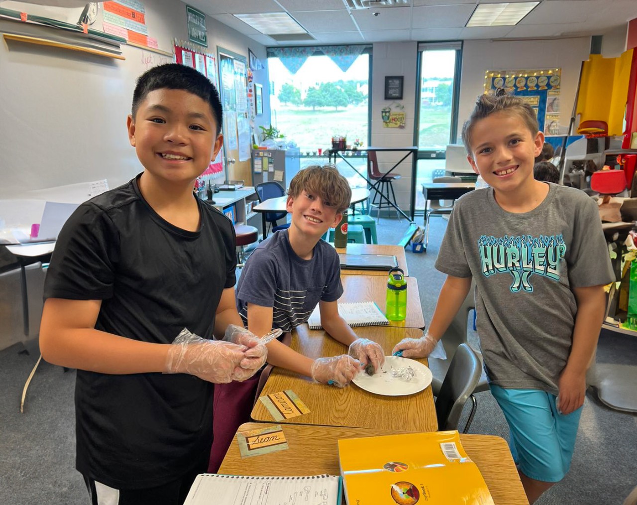 Three students work on a project in a science class.